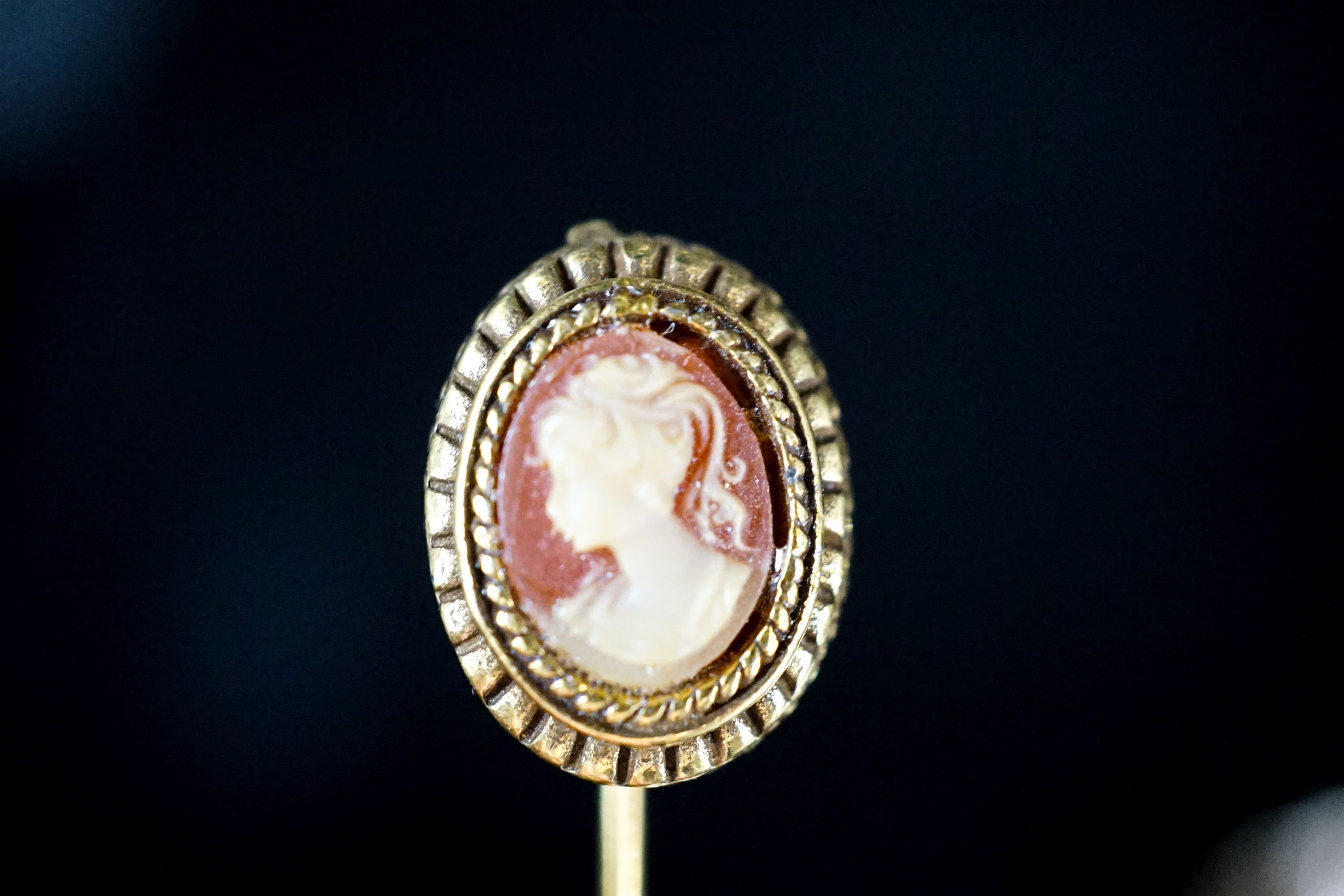 Two mounted cameo shell pendants, one with brooch attachment and a gilt metal cameo pin.